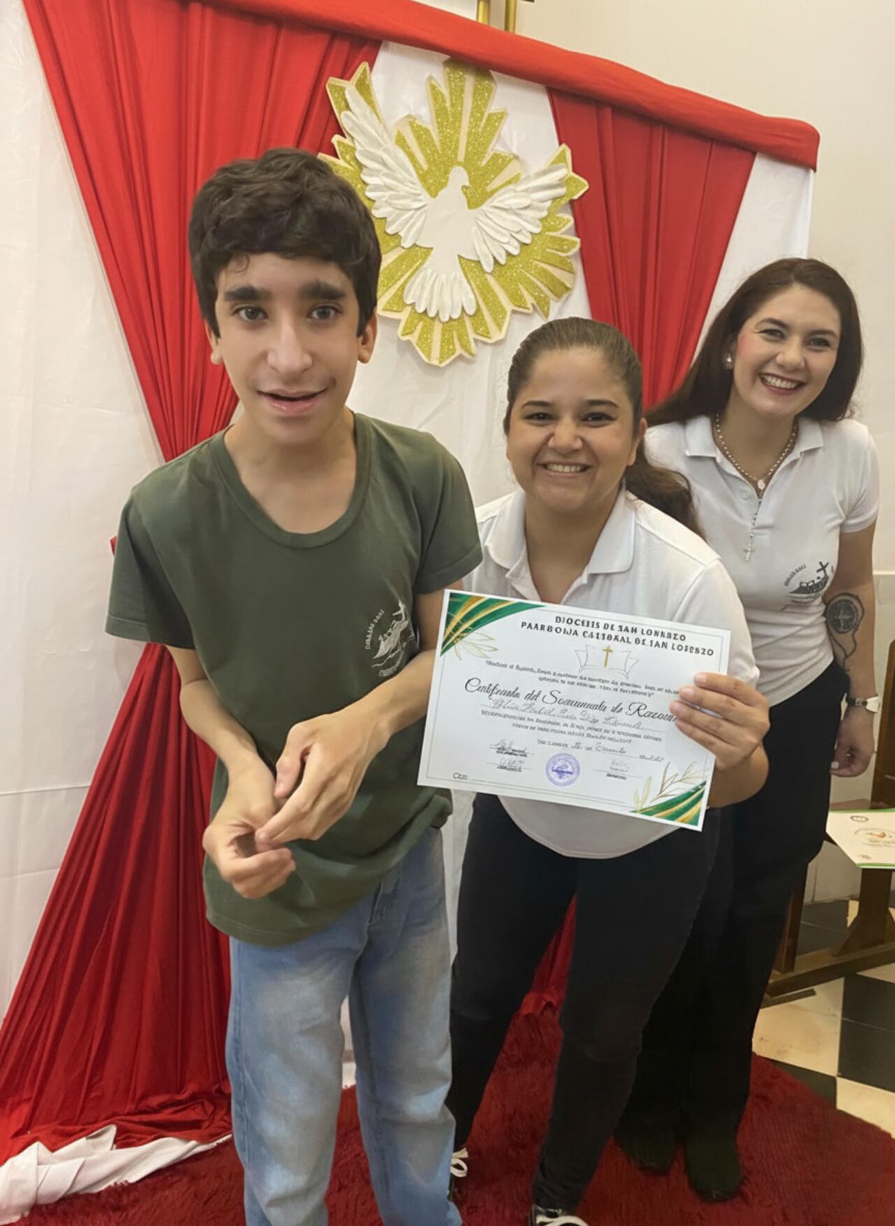 El joven posando junto a sus catequistas Raquel y Verónica en la culminación de su primera confesión.
