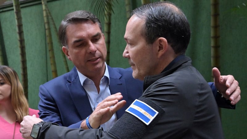 El senador Flavio Bolsonaro (i) saluda a al ministro de Justicia de El Salvador, Gustavo Villatoro, en Sao Paulo, Brasil.