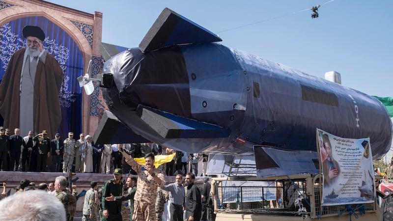 Un globo con forma de submarino no tripulado, que según el Cuerpo de la Guardia Revolucionaria Islámica (CGRI) fue atacado por sus fuerzas mientras patrullaban el estrecho de Ormuz, es transportado en un vehículo frente a un retrato del difunto líder supremo de Irán, el ayatolá Ali Jamenei, durante un desfile militar en el centro de Teherán, Irán. (AFP)