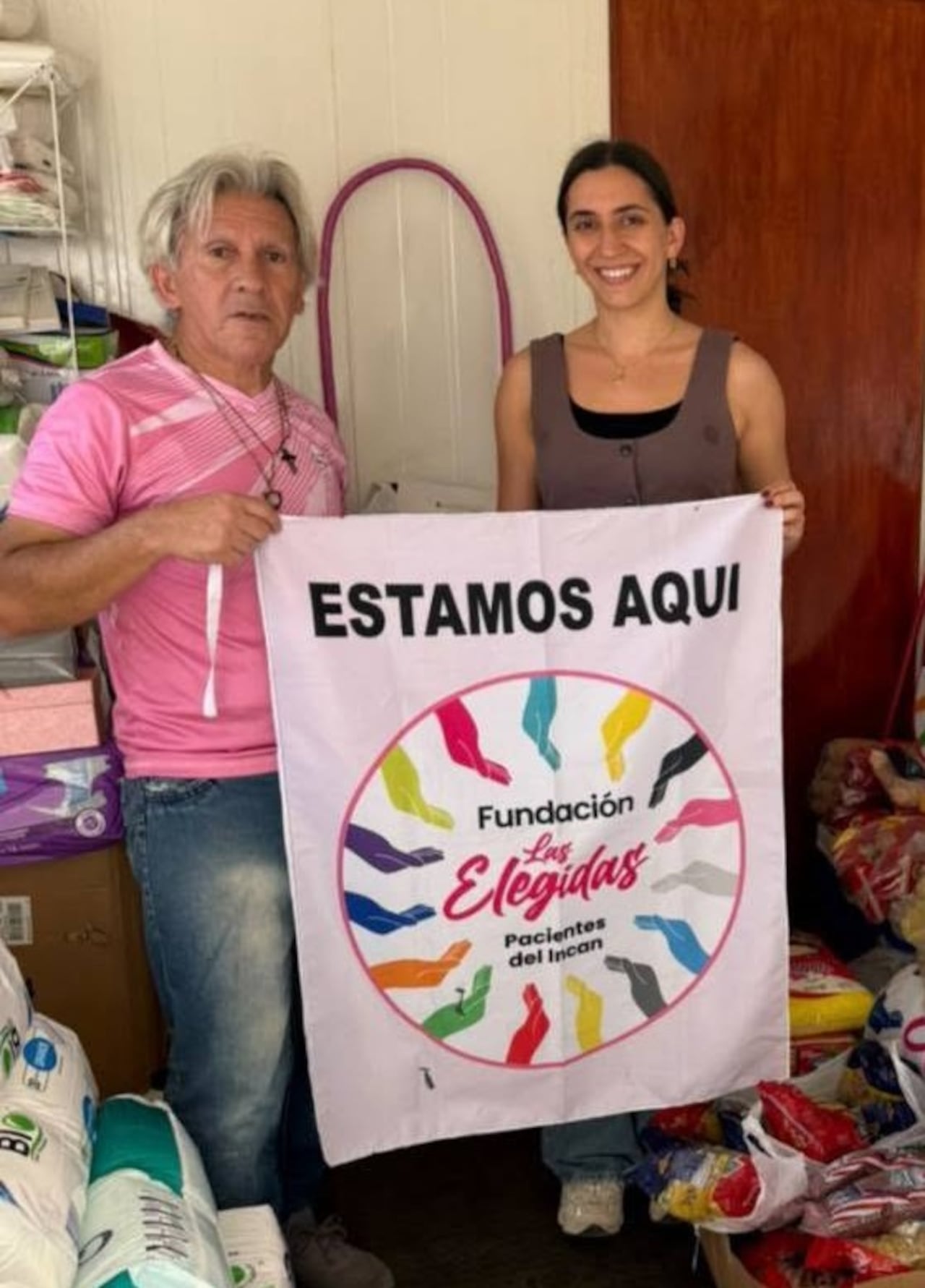 Juan Cabrera sostiene el cartel de la fundación junto a una de las tantas voluntarias que, con su donación, ayuda a mantener viva la esperanza en el Incan.