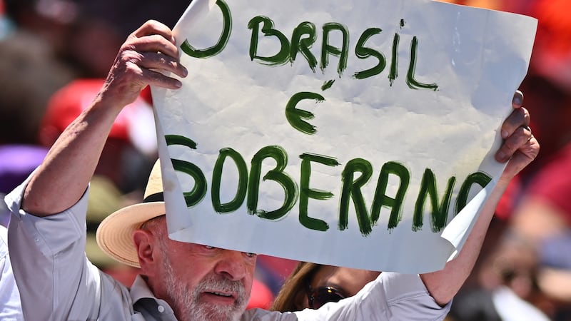El presidente de Brasil, Luiz Inácio Lula da Silva, sostiene un cartel durante un acto de campaña , en Brasilia (Brasil). "¡Vamos a ganar estas elecciones! (...) ¡Pueden estar seguros de que este país no volverá a ser gobernado por el fascismo!", exclamó el líder progresista encima de una camioneta, rodeado de cientos de militantes vestidos de rojo, en Ceilândia, en la periferia de Brasilia.
