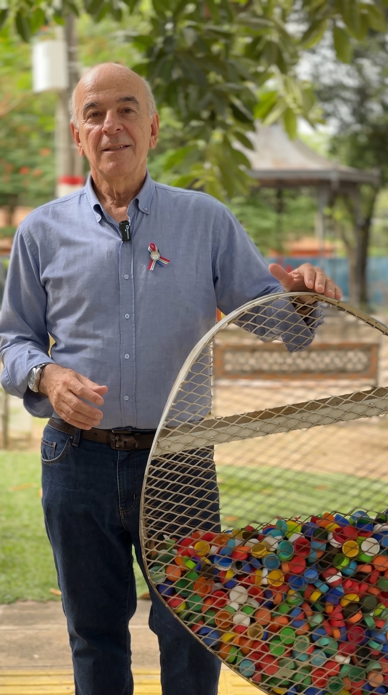 Pequeñas acciones, grandes resultados. El doctor Luis López junto a un contenedor de tapitas en la plaza local, reflejo de su compromiso por llevar la educación ambiental a cada rincón de la comunidad.