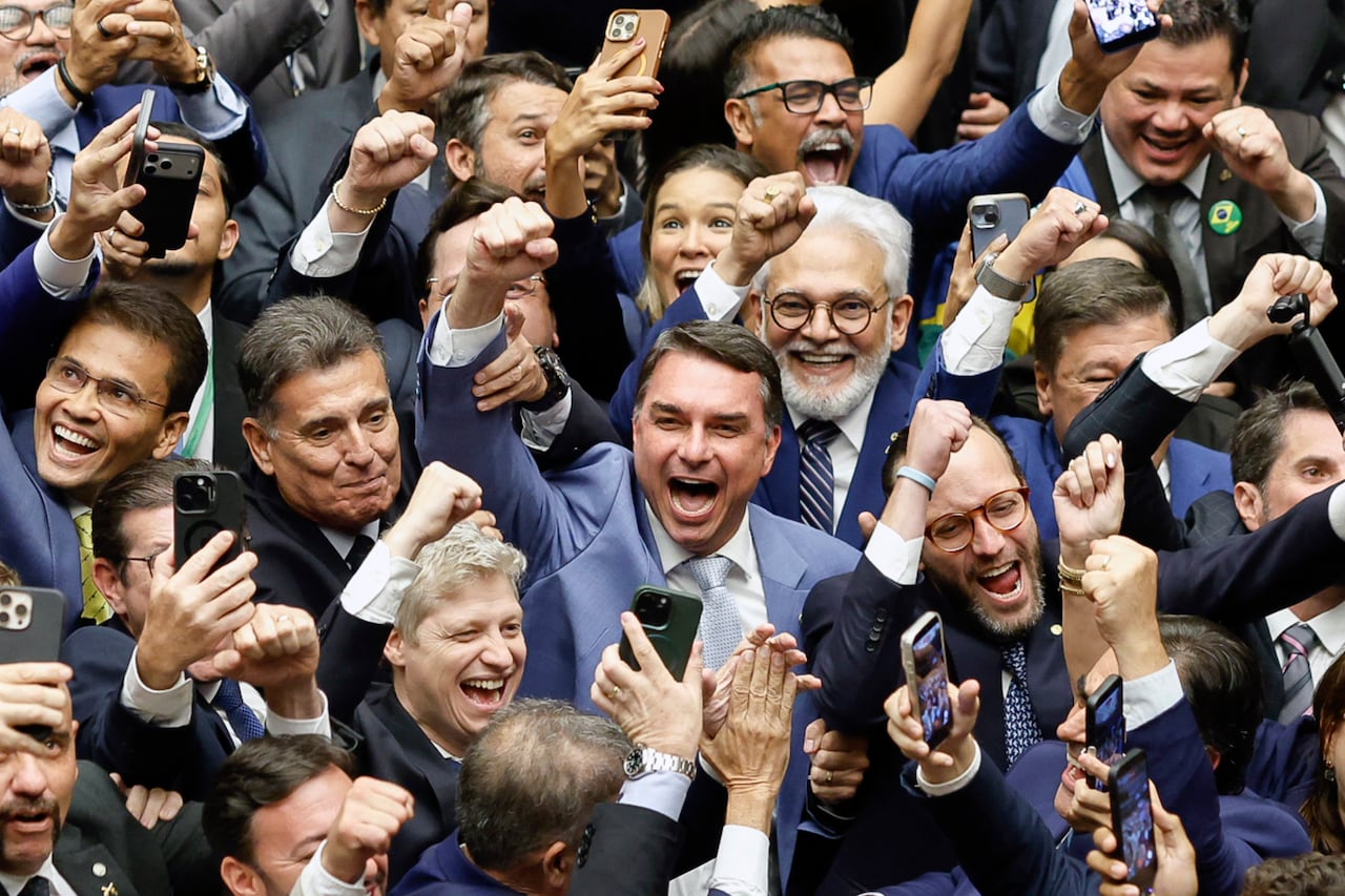 Senator Flavio Bolsonaro (C) celebrates during a National Congress session that overturned President Lula's veto of a bill reducing sentences for those convicted over the attempted coup d'etat and the acts of January 8, 2023, in Brasilia on April 30, 2026. (Photo by Sergio Lima / AFP)