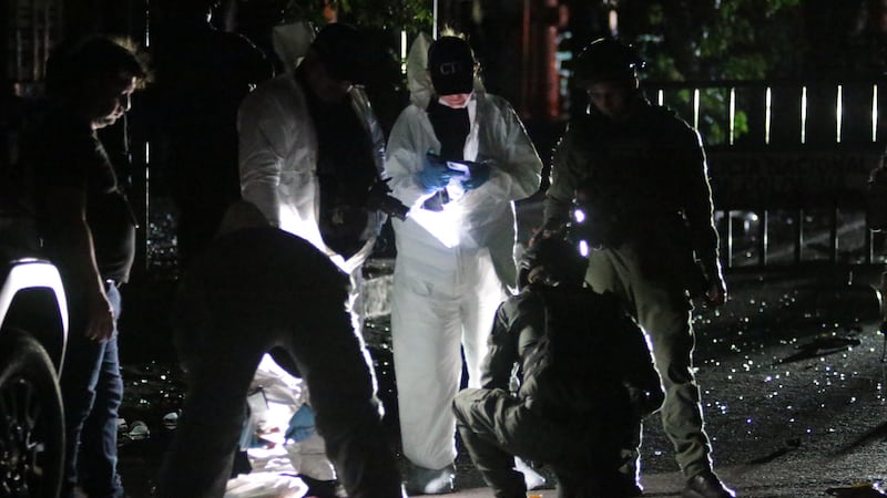 Policías e investigadores inspeccionan la estación de policía luego de que un coche bomba fuera detonado en Los Patios (Colombia).