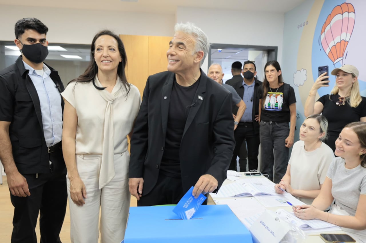 El ex primer ministro israelí y líder del opositor Beyajad, Yael Lapid (c), vota acompañado por su esposa en Tel Aviv en las elecciones generales en Israel.