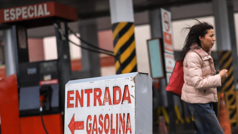 Una mujer camina frente a una estación de servicio cerrada hoy, en La Paz (Bolivia).