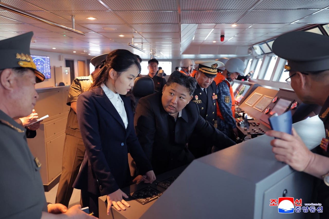 El presidente de Norcorea, Kim Jong Un (c) junto a su hija Kim Ju Ae (centro a la izq.) observando el desarrollo de un destructor en un sitio no confirmado por las autoridades de Corea del Norte.