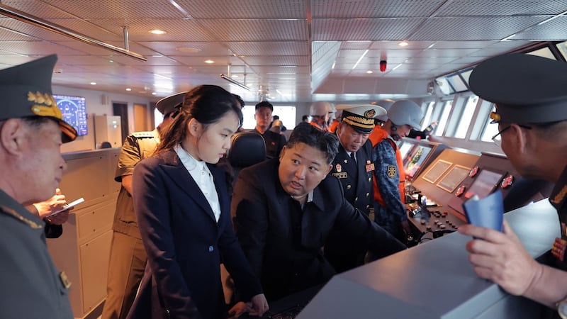 El presidente de Norcorea, Kim Jong Un (c) junto a su hija Kim Ju Ae (centro a la izq.) observando el desarrollo de un destructor en un sitio no confirmado por las autoridades de Corea del Norte.