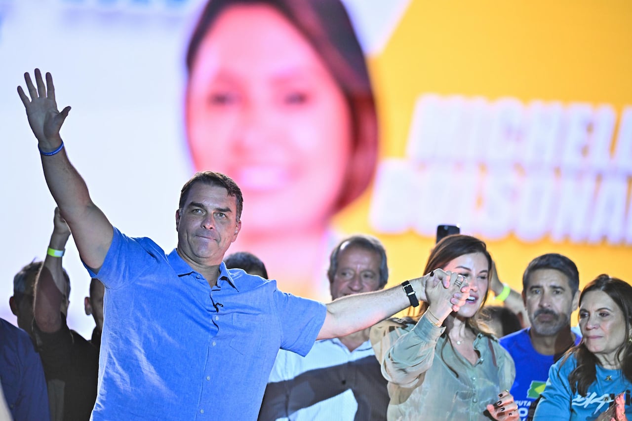 El senador y candidato a la presidencia de Brasil por el Partido Liberal Flávio Bolsonaro reacciona junto a su esposa, Fernanda Bolsonaro, durante la convención regional de su partido este domingo, en el 'Parque da Cidade' en Brasilia (Brasil).