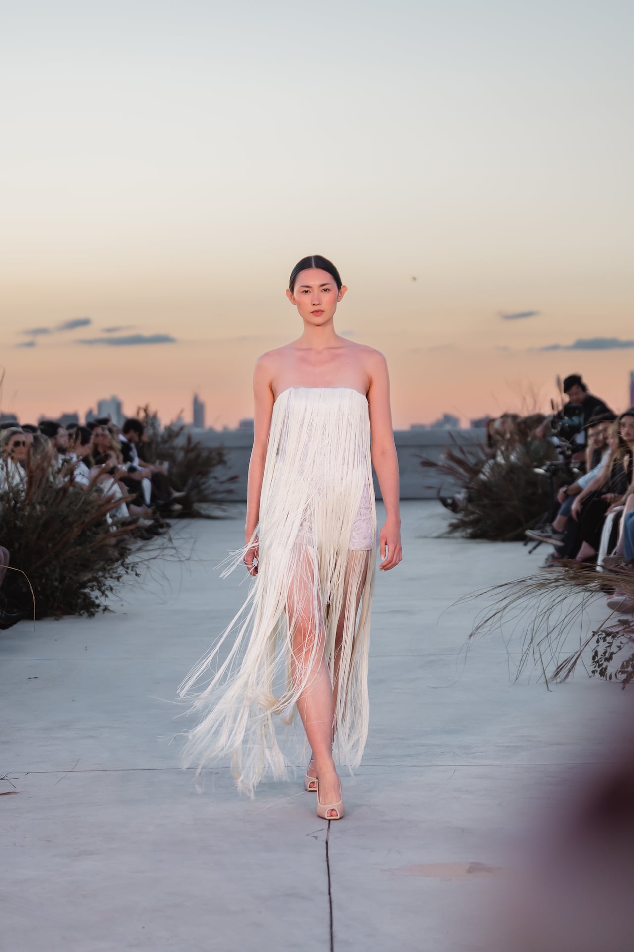 El dinamismo de los flecos en un diseño strapless de color off-white.