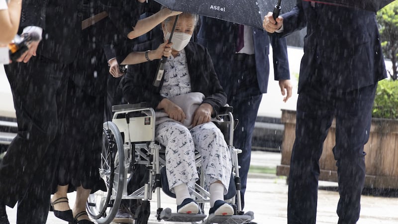 La líder de la secta Moon Han Hak-ja (centro, en silla de ruedas) sale de una Corte de Seúl.