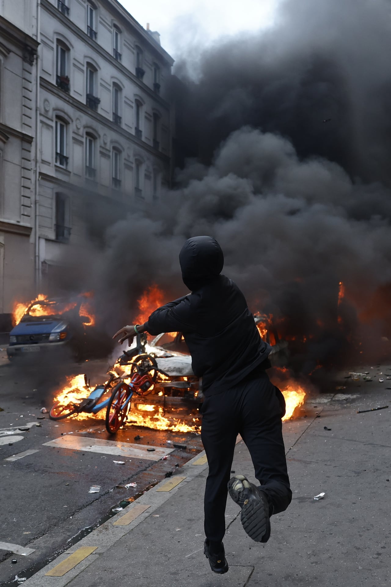 Un manifestante lanza un proyectil durante las protestas ayer en París, Francia.