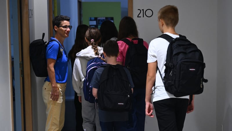 Una docente recibe a los alumnos en la escuela pública de Cambo-les-Bains, Francia. Los estudiantes vuelven a las clases sin teléfonos móviles.