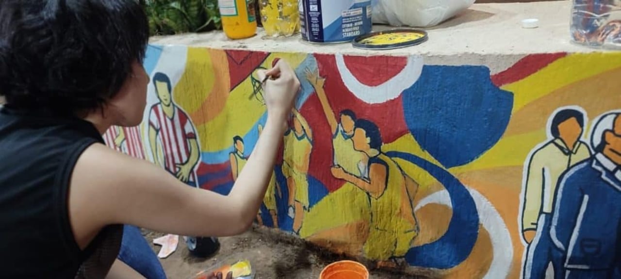 Artistas pintando murales en canteros ornamentales de Encarnación