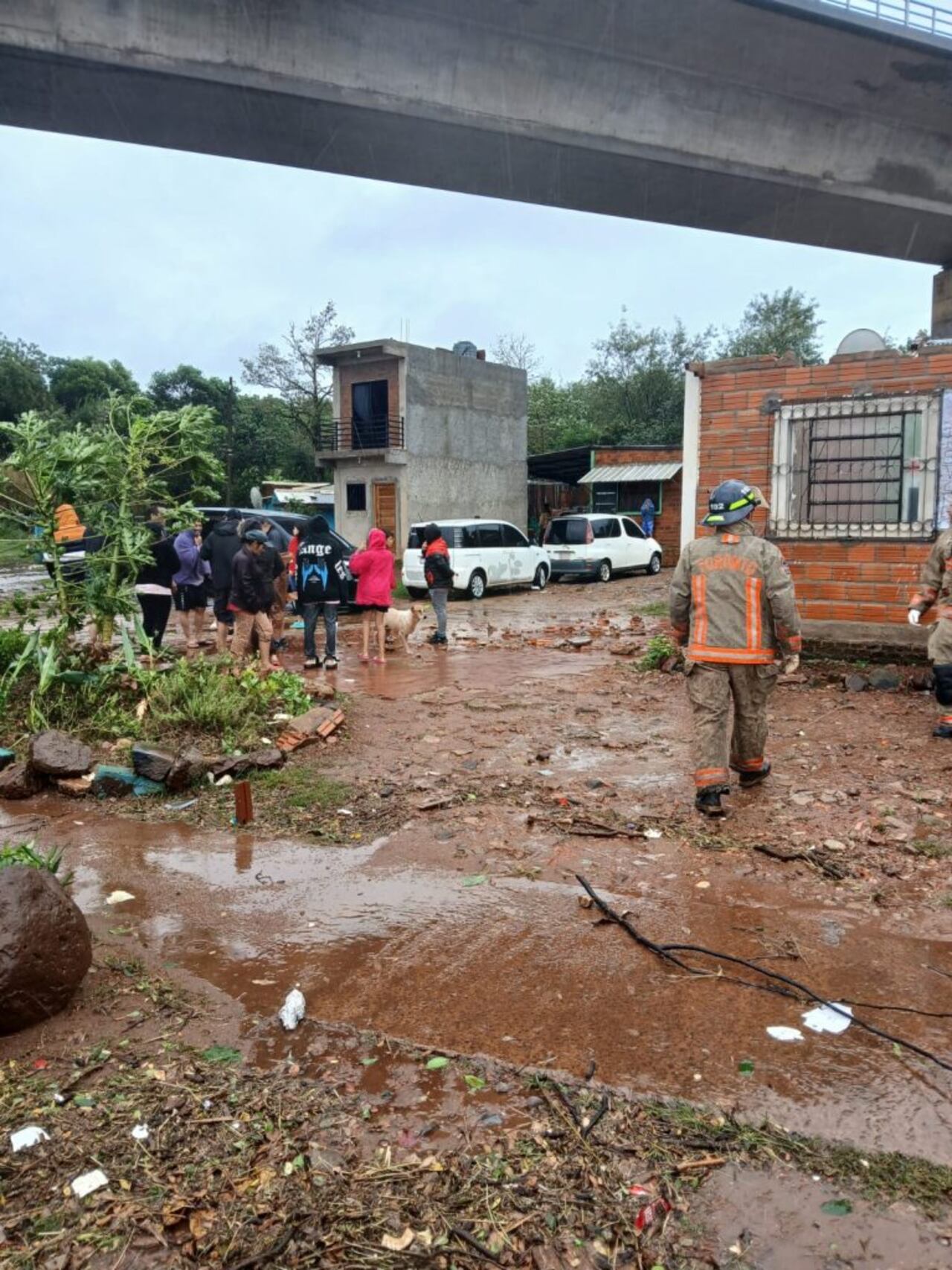Bomberos voluntarios auxiliaron a familias afectadas por el temporal en el barrio "Sagra Familia", en cercanías al puente internacional "San Roque González de Santa Cruz".