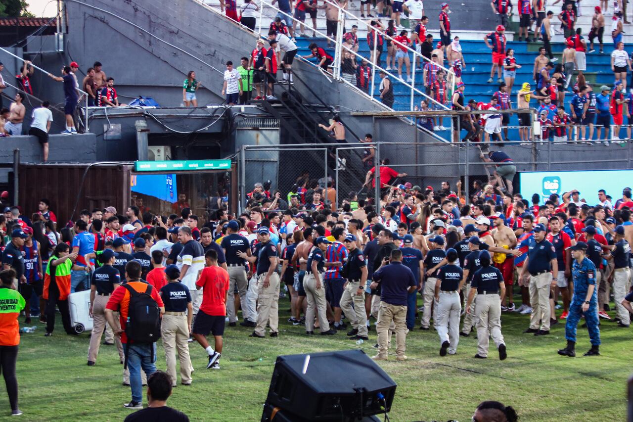 Invasión de campo de juego. Huyendo del caos, muchos hinchas pisaron el césped del Defensores del Chaco.
