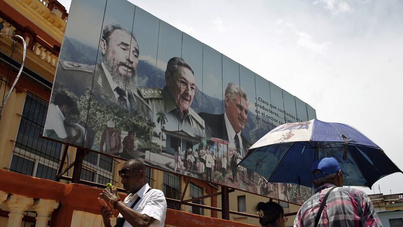 Gigantografía con la imagen de los expresidentes de Cuba y líderes de la revolución comunista: Fidel Castro (falleció en 2016) y Raúl Castro, junto al actual mandatario Miguel Díaz Canel, en La Habana. (AFP)